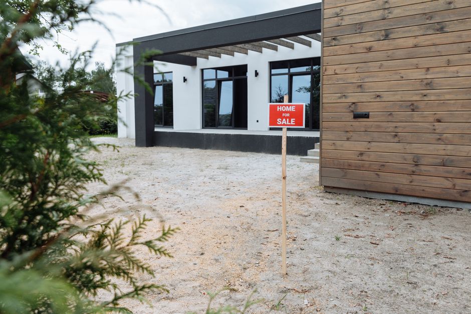 Beautiful New Orleans shotgun house with a 'For Sale' sign in the front yard on a bright, sunny day, representing increase...