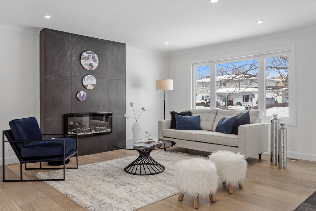 A comfortable and cool modern living room interior, with bright sunlight streaming through a large window, showcasing an energy-efficient home.