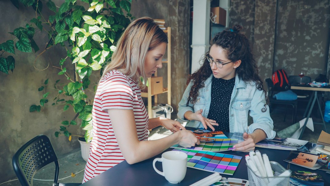 A homeowner thoughtfully comparing paint color swatches against a wall, representing the strategic decision-making process for renovations that pay off.