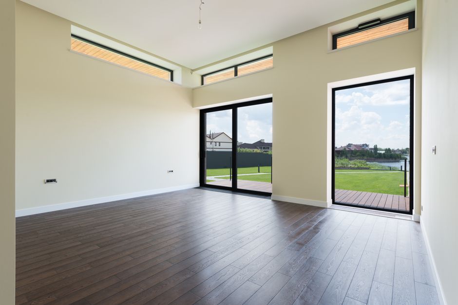 Sunlight streams into a beautiful, modern open-plan house that is completely empty, representing the decline in visitor traffic for real estate websites due to AI search.